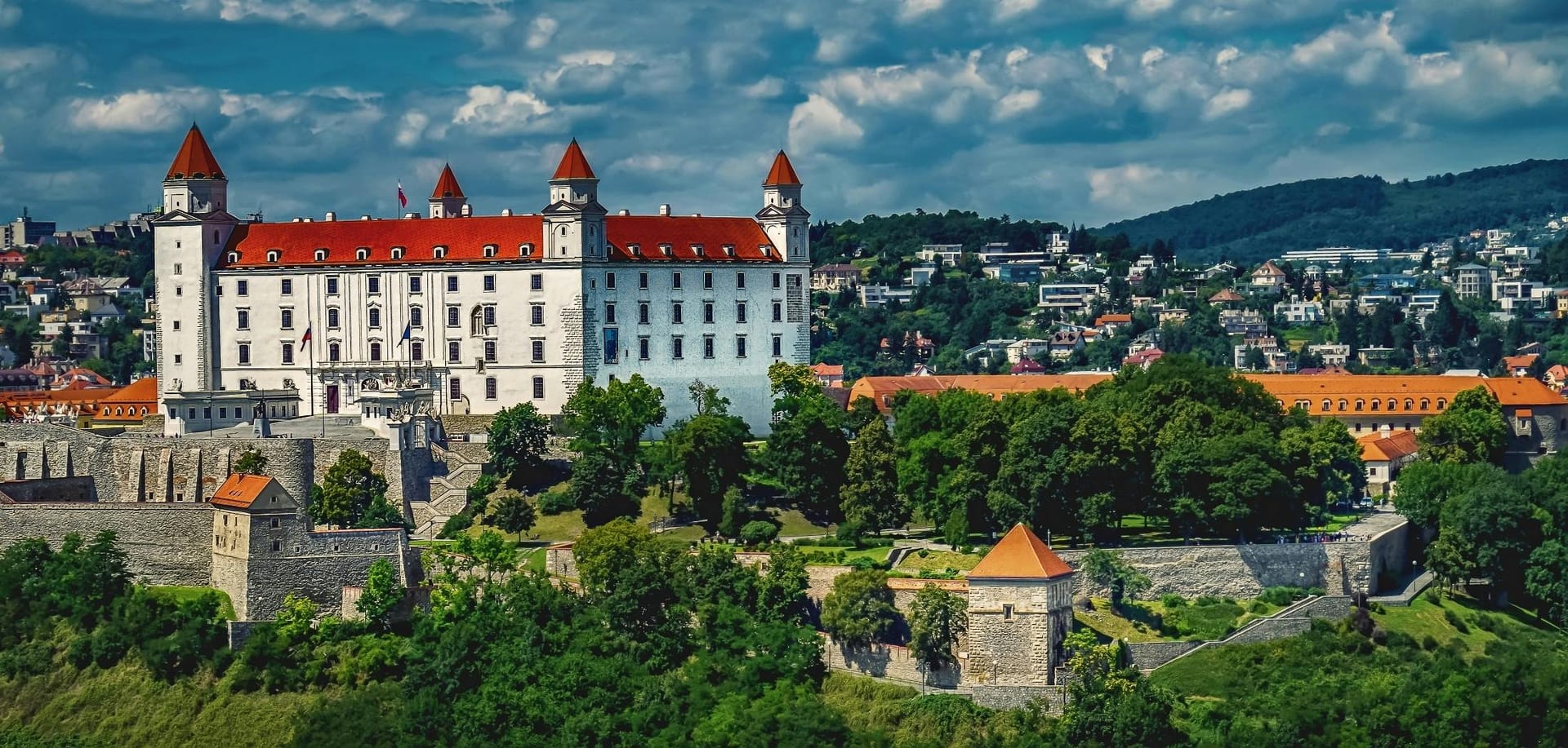 Bratislava Castle on a hilltop overlooking the Danube River and cityscape with red-roofed buildings