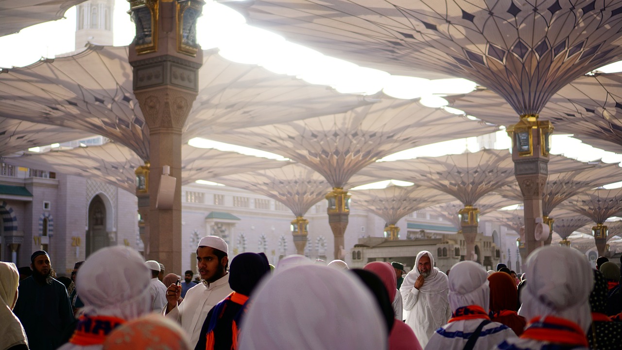 The large convertible umbrellas shading the courtyard of Al-Masjid an-Nabawi in Medina, with crowds of people underneath.